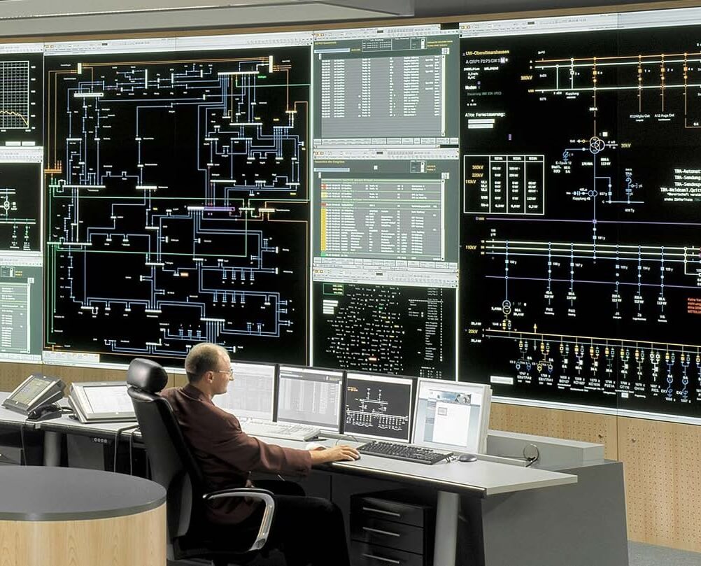 IT-Operations-Center mit zahlreichen Bildschirmen und Übersichtskarten