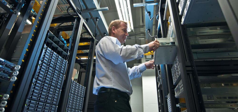 A man in a data center working on a server rack