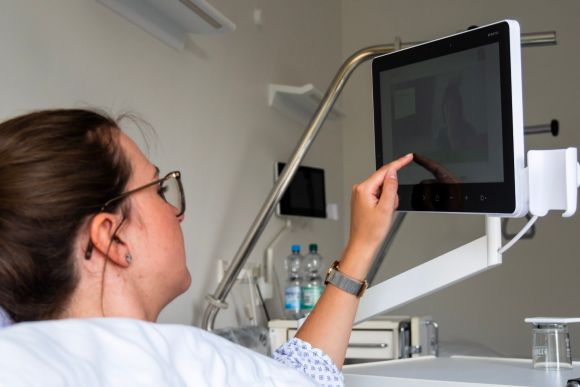 Patient in a hospital in her bed accessing a tablet 